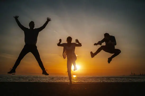 salto playero de amigos al atardecer